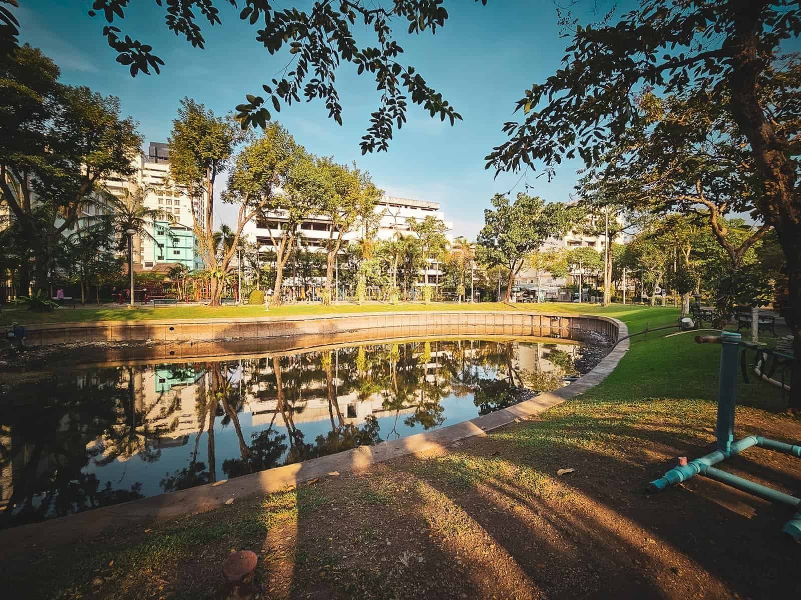 A quiet tree-lined city park in the middle of Bangkok at dawn