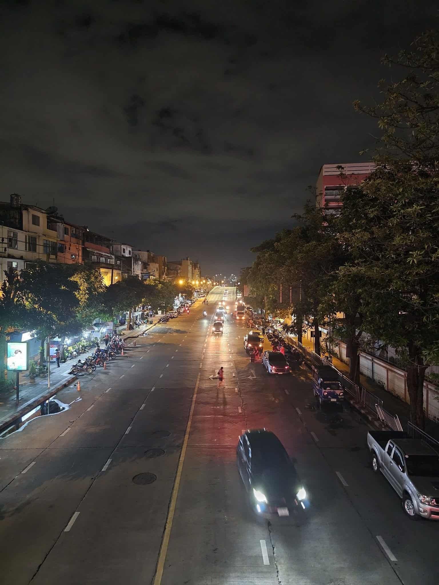 Tangled electrical wires and neon over a Bangkok street at night