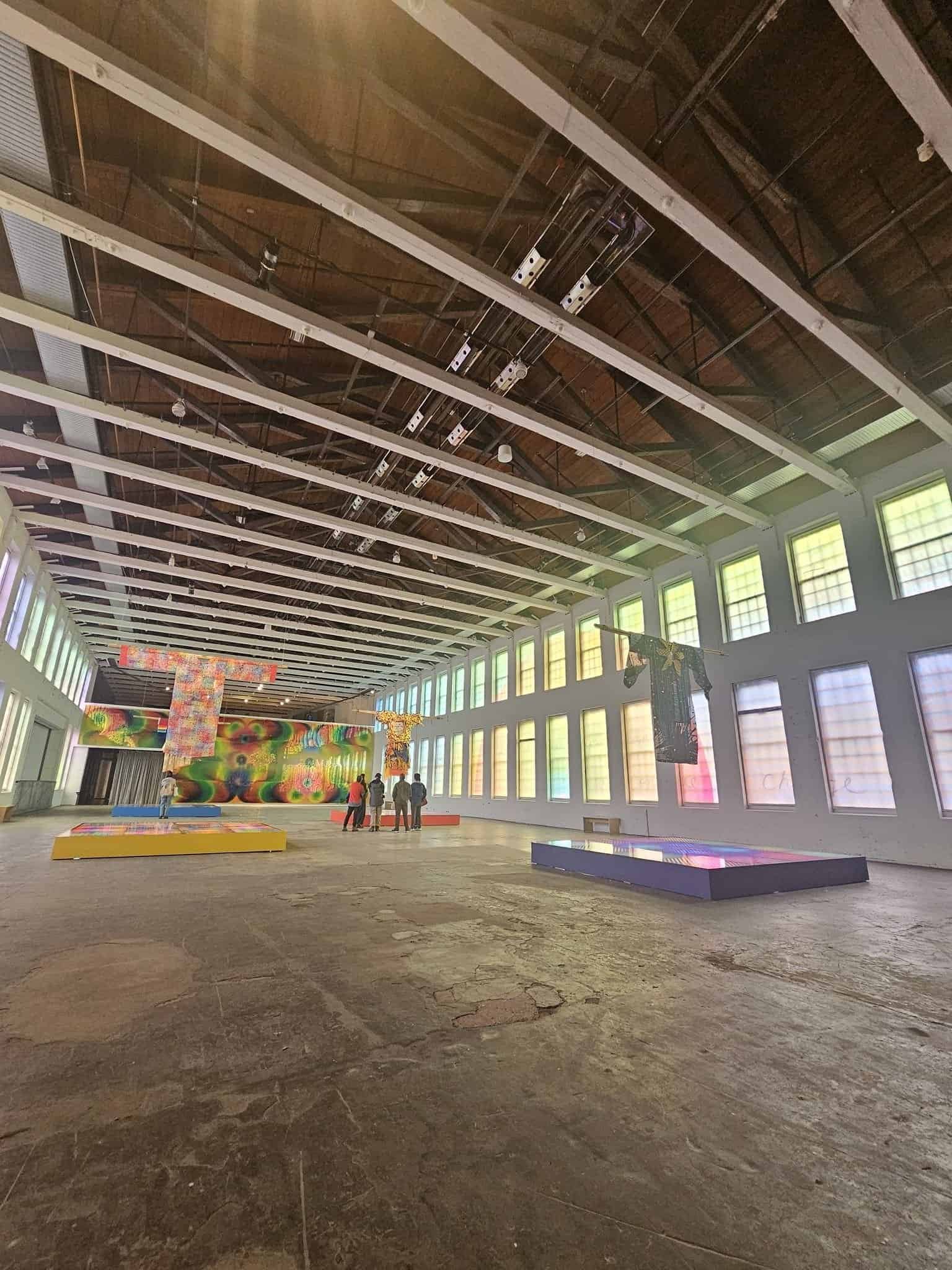 Mass moca: a weekend inside massachusetts' wildest art museum 15 » 2026 » roaming sparrow A large immersive gallery installation with hanging wardrobes at Mass MoCA
