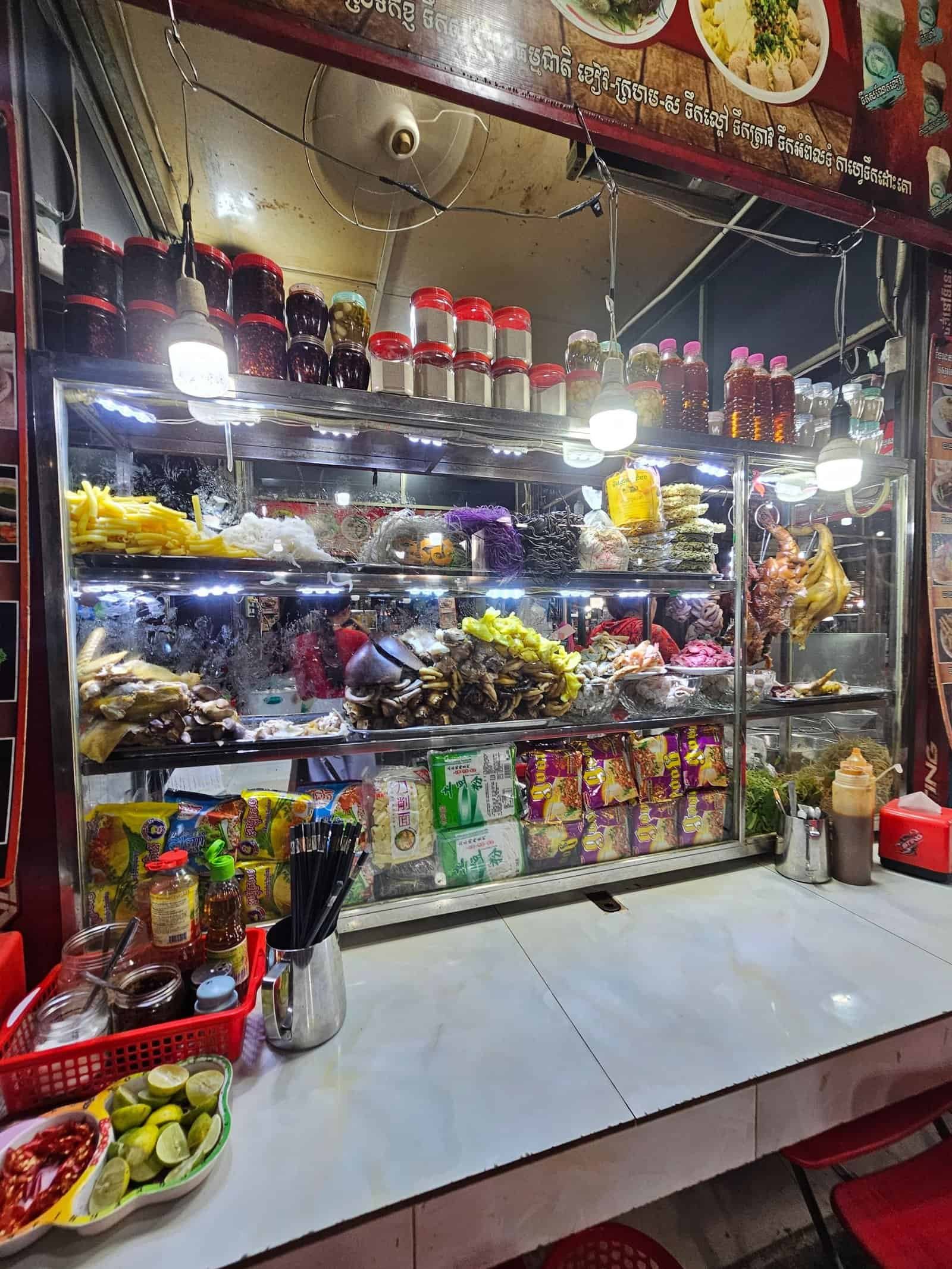 Phnom penh on foot: bassac lane, the riverside, and a day of wandering 28 » 2026 » roaming sparrow Kandal Market in Phnom Penh with its blue sign and parked motorbikes
