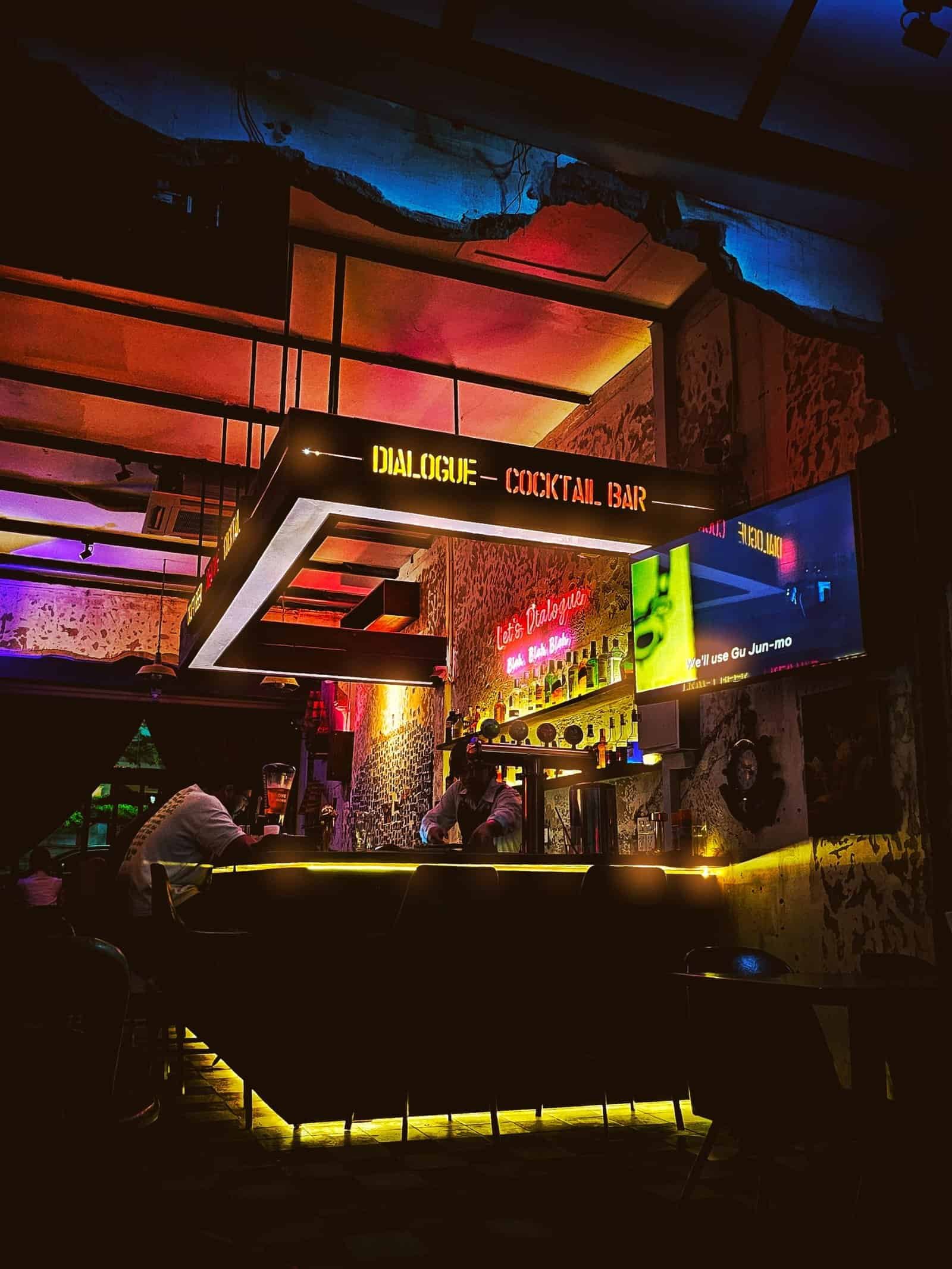 The distressed concrete and neon interior of Dialogue 2.0 bar in Siem Reap
