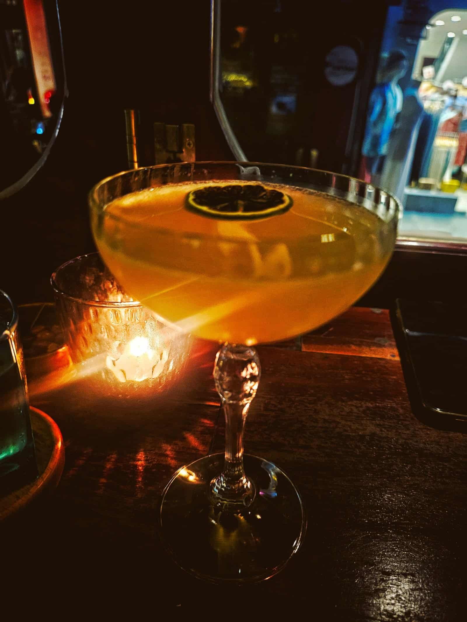 A Negroni in candlelight with a bright street reflected behind, Siem Reap bar