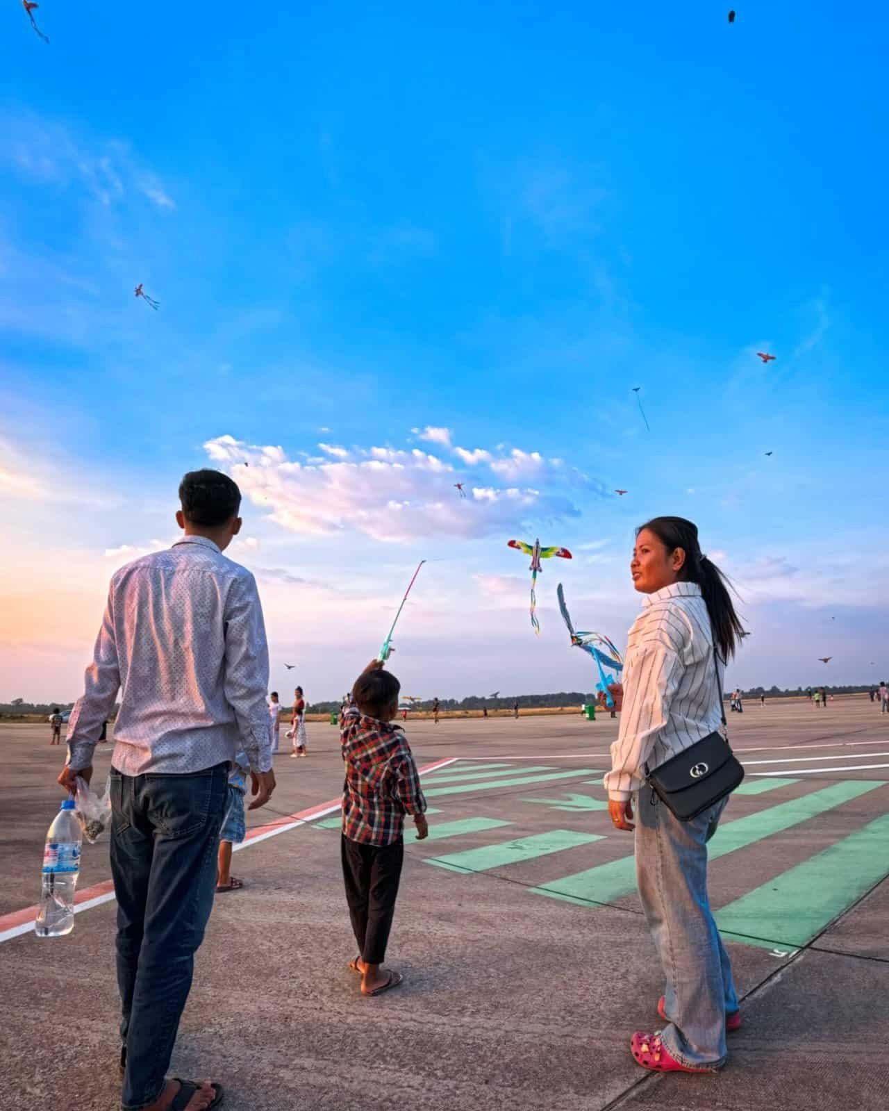 Kite flyers at the Siem Reap Kite Festival during golden hour