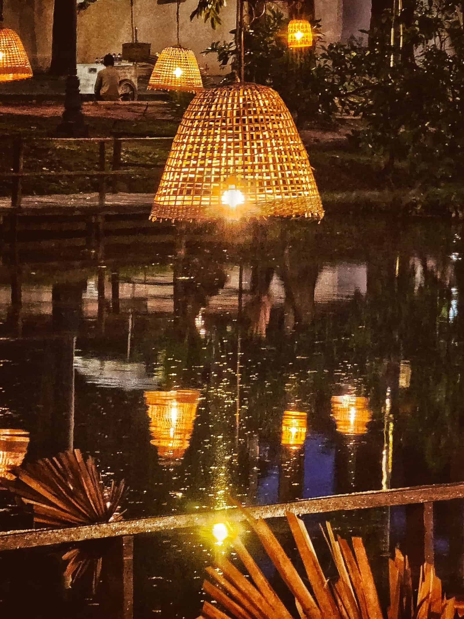Blue-hour view over a lantern-lit pond and wooden dock in Siem Reap