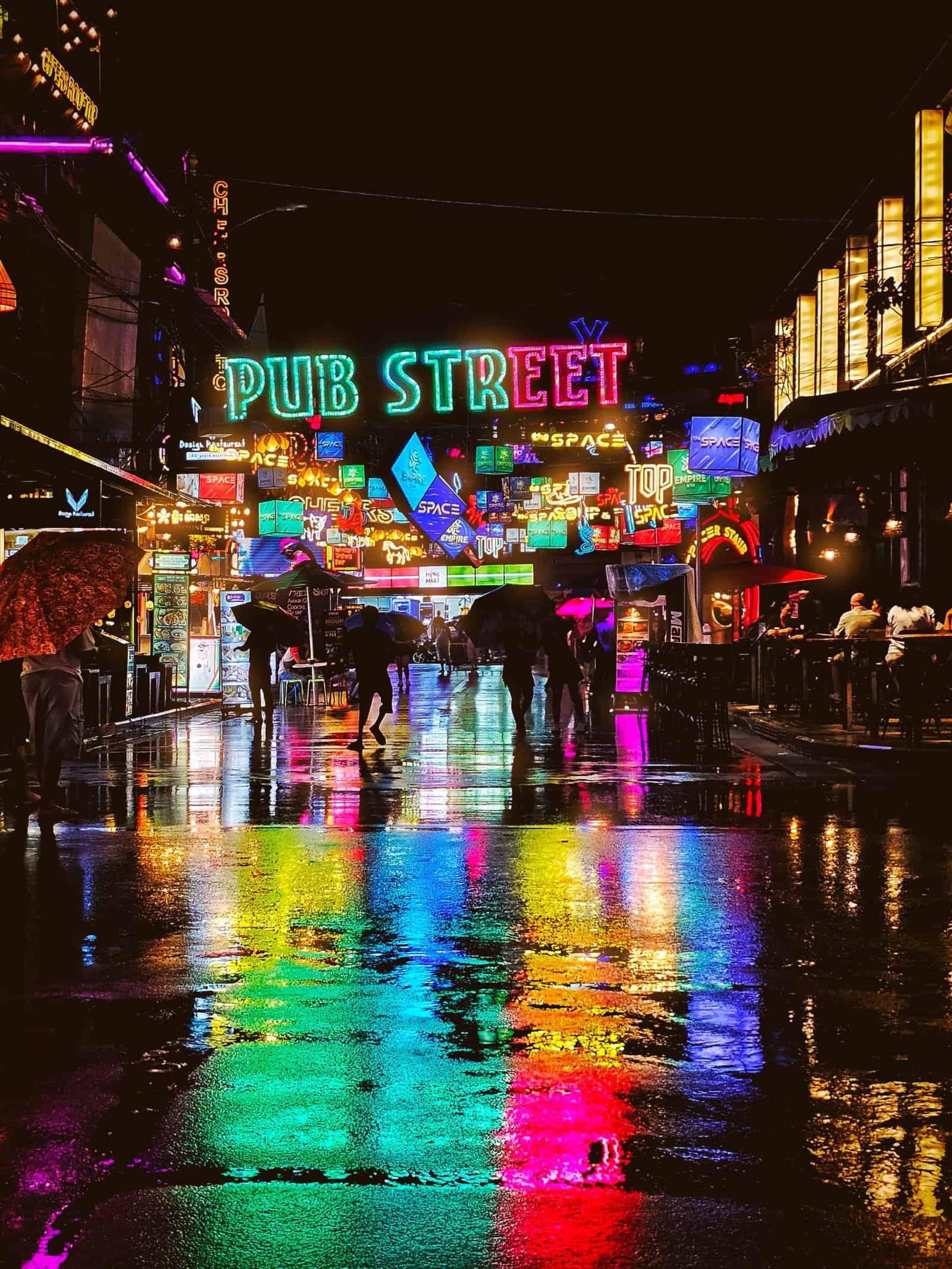 The Pub Street arch reflected in wet pavement on a rainy Siem Reap night